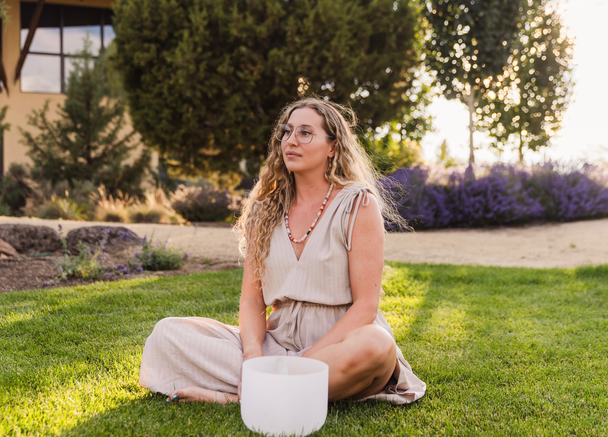 Larissa Bell seated outdoors with a sound bowl
